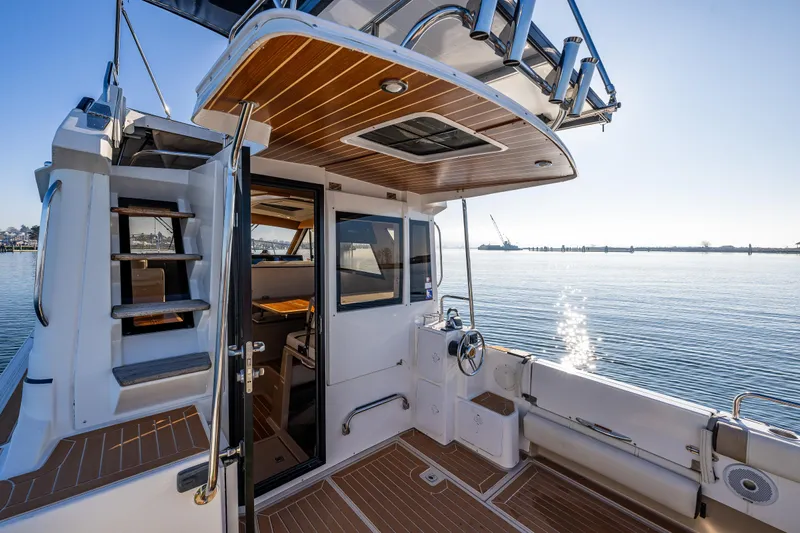 Awol Yacht Photos Pics 2016 Cutwater 30 Command Bridge boat with open cabin, docked on calm water.