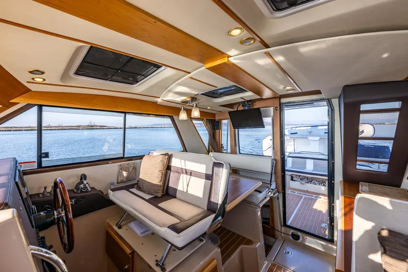 Awol Yacht Photos Pics Interior of 2016 Cutwater 30 Command Bridge boat with seating and helm, overlooking water.