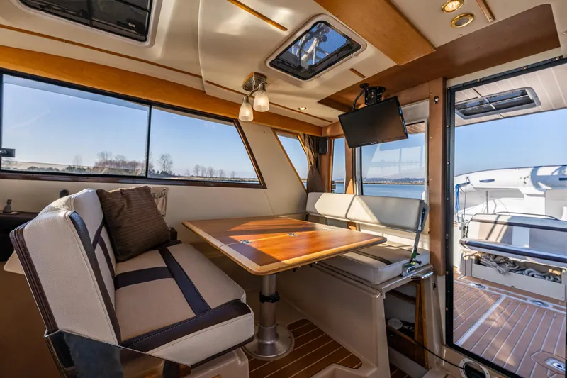 Awol Yacht Photos Pics Interior of 2016 Cutwater 30 Command Bridge with dining area and large windows.