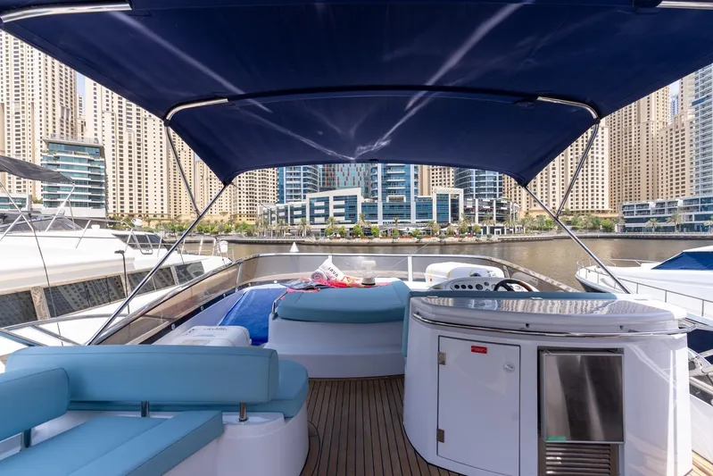 Java Yacht Photos Pics 2004 Sunseeker Manhattan 64 yacht interior with marina view, featuring blue seating and canopy.