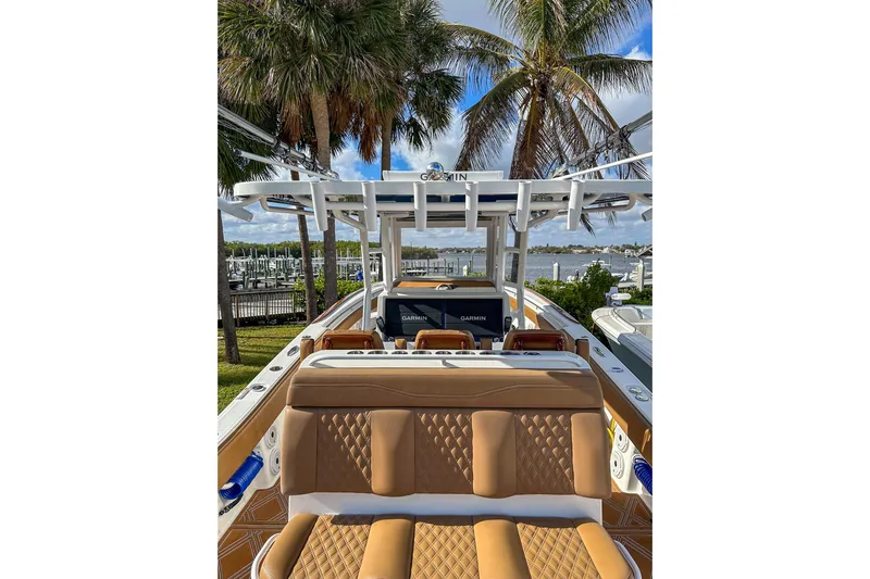  Yacht Photos Pics 2022 Invincible 39 Open Fisherman boat with tan seating, docked near palm trees and water.