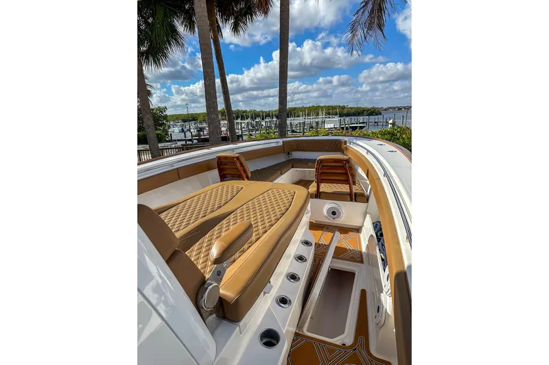  Yacht Photos Pics 2022 Invincible 39 Open Fisherman boat interior with tan seating and scenic marina view.