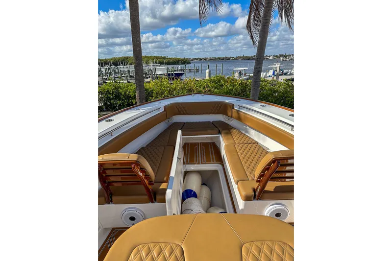  Yacht Photos Pics 2022 Invincible 39 Open Fisherman boat with tan seating, docked by a scenic waterfront.