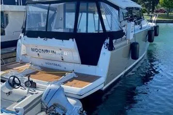  Yacht Photos Pics 2014 Jeanneau NC 14 boat docked, featuring a covered deck and outboard motor.