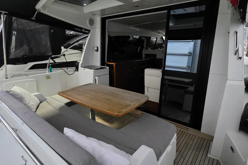  Yacht Photos Pics 2014 Jeanneau NC 14 yacht interior with seating and wooden table.