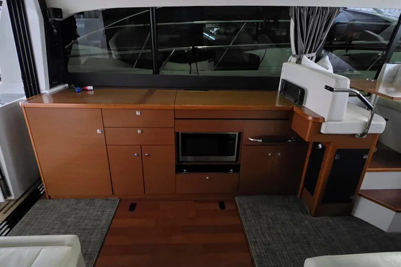  Yacht Photos Pics Interior of 2014 Jeanneau NC 14 yacht with wooden cabinetry and modern appliances.