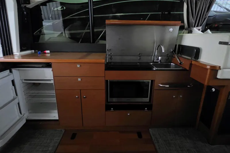  Yacht Photos Pics 2014 Jeanneau NC 14 yacht kitchen with sink, microwave, and open fridge.