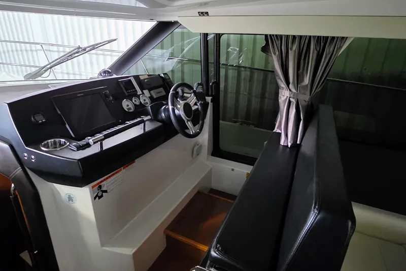  Yacht Photos Pics Interior helm of 2014 Jeanneau NC 14 boat with steering wheel and navigation controls.