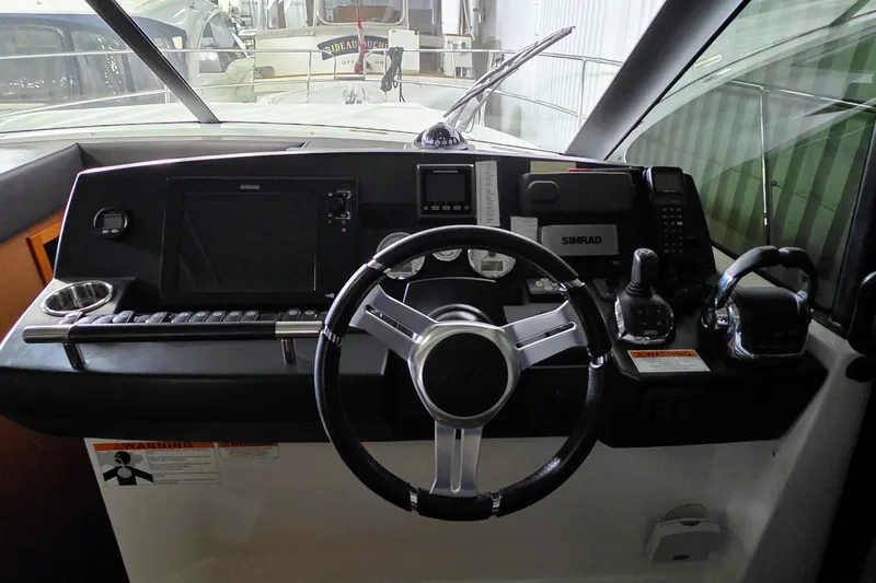  Yacht Photos Pics Cockpit of 2014 Jeanneau NC 14 boat with steering wheel and navigation controls.