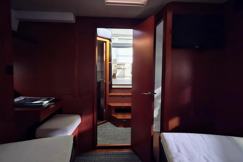  Yacht Photos Pics Interior of 2014 Jeanneau NC 14 yacht cabin with wooden furnishings and cozy seating.