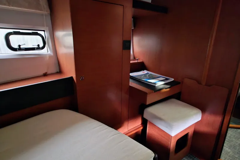  Yacht Photos Pics 2014 Jeanneau NC 14 cabin interior with desk, stool, and window.