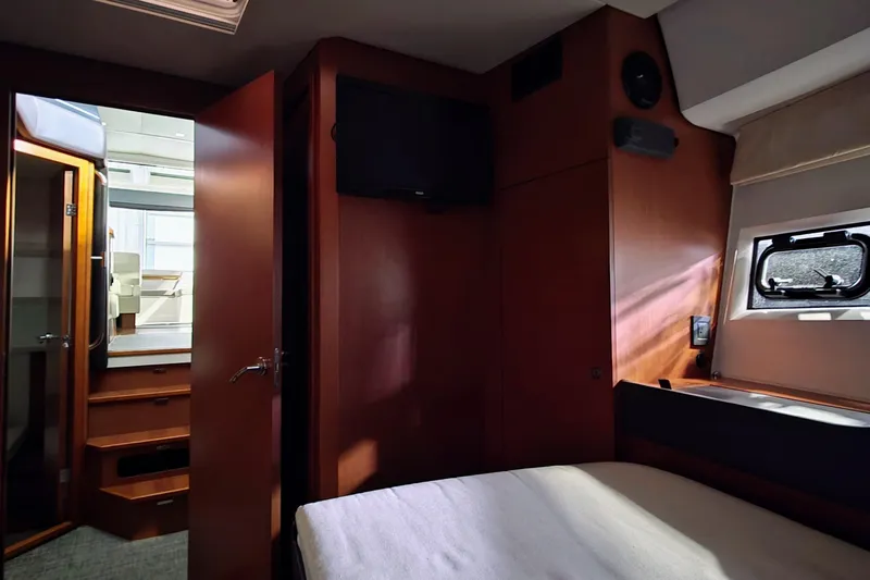  Yacht Photos Pics Interior of 2014 Jeanneau NC 14 yacht cabin with wood finish and window.