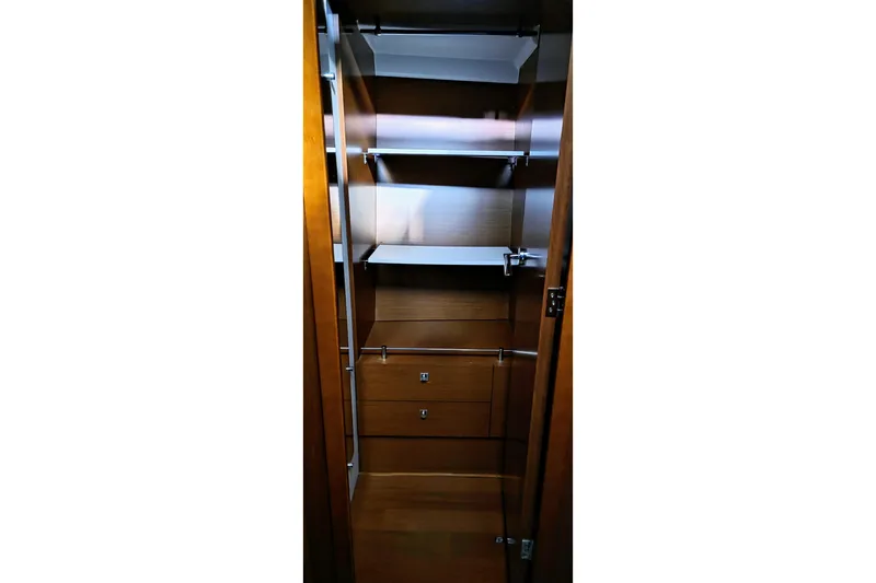  Yacht Photos Pics 2014 Jeanneau NC 14 yacht interior closet with wooden shelves and drawers.