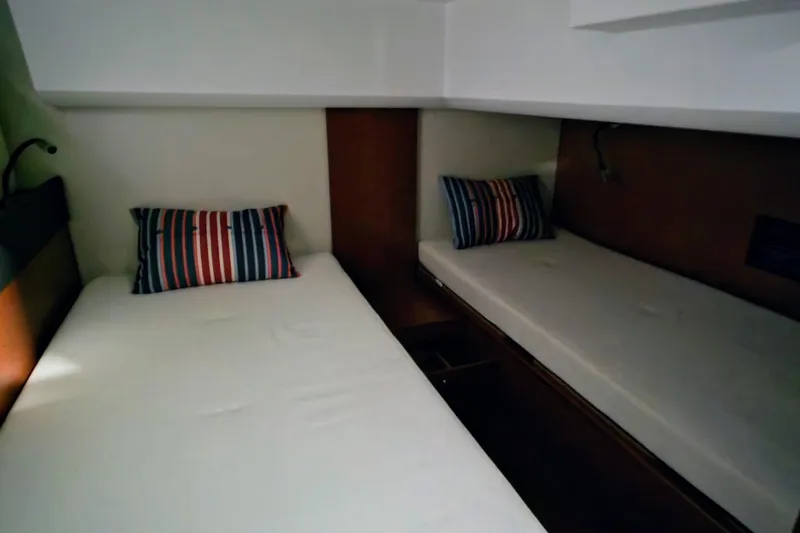  Yacht Photos Pics 2014 Jeanneau NC 14 cabin interior with twin beds and striped pillows.