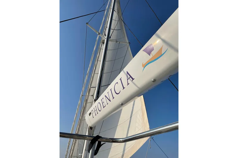 Phoenicia Yacht Photos Pics Sail of Lagoon 620 yacht, 2014 model, with "PHOENICIA" branding against clear sky.