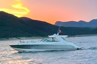 Obstreperous Yacht Photos Pics 2004 Formula 400 Super Sport yacht cruising at sunset with mountainous backdrop.
