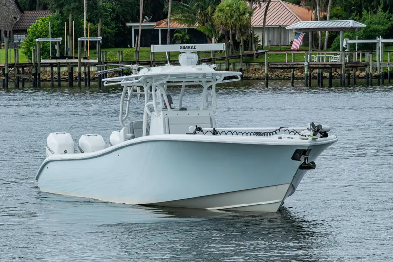  Yacht Photos Pics 2018 Yellowfin 36 Offshore boat on calm water near a dock.