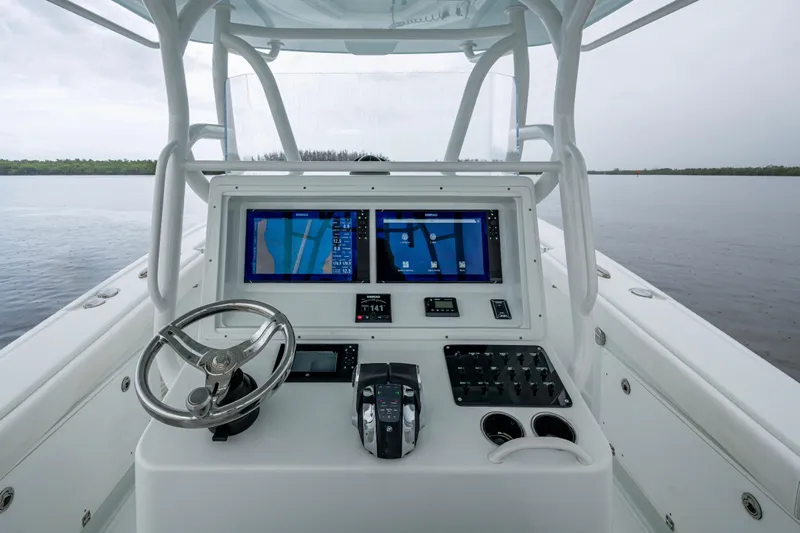  Yacht Photos Pics 2018 Yellowfin 36 Offshore boat dashboard with dual navigation screens on calm water.