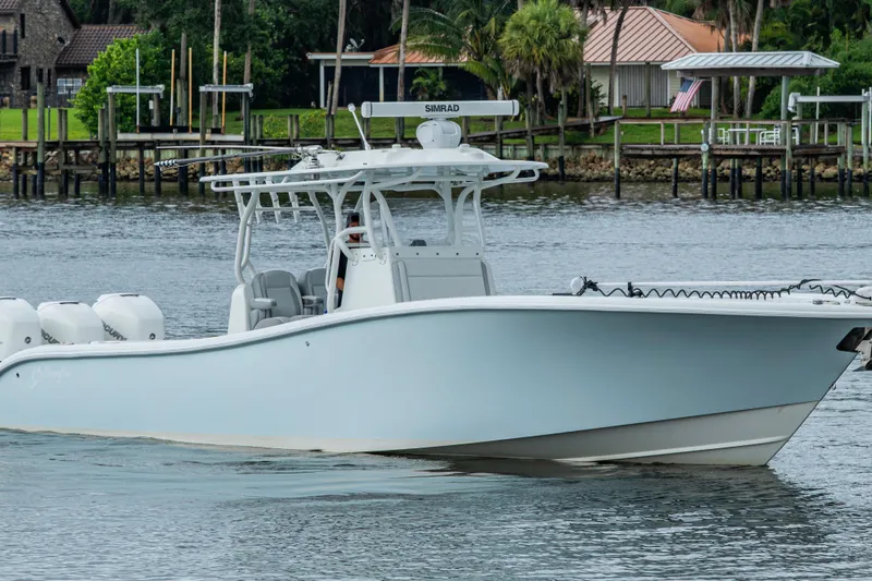  Yacht Photos Pics 2018 Yellowfin 36 Offshore boat cruising on a calm river near docks.