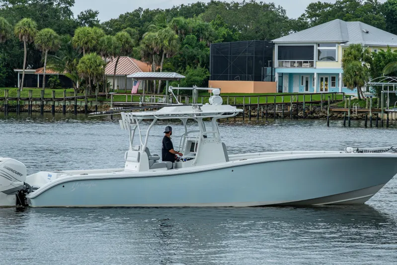  Yacht Photos Pics 2018 Yellowfin 36 Offshore boat cruising near waterfront homes.