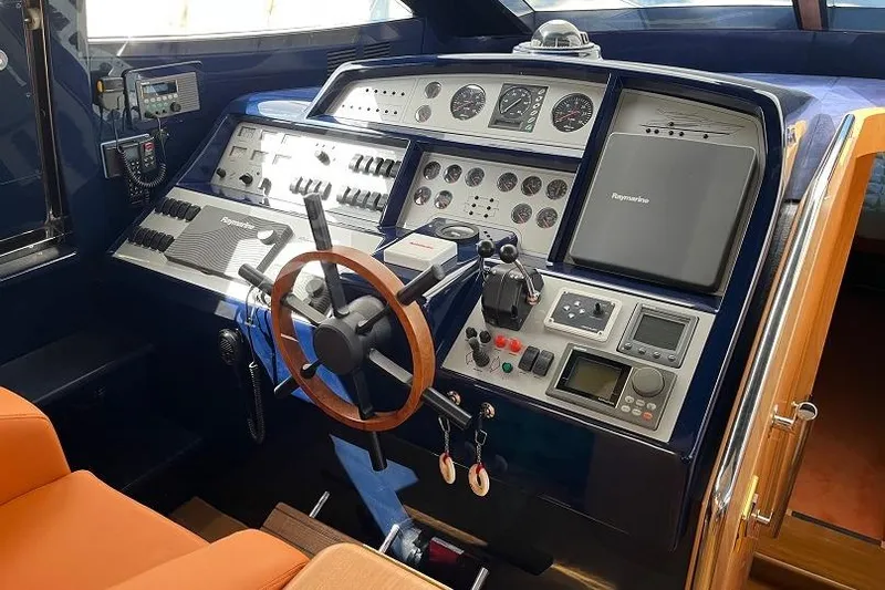  Yacht Photos Pics Control panel of a 1998 Riva Dolce Vita yacht with wooden steering wheel.