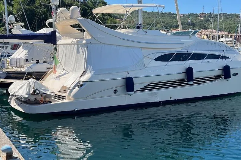  Yacht Photos Pics Luxury 1998 Riva Dolce Vita yacht docked in a serene marina setting.