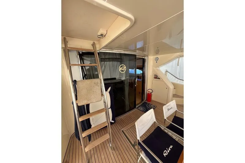  Yacht Photos Pics Interior of 1998 Riva Dolce Vita yacht with ladder, chairs, and sliding glass door.