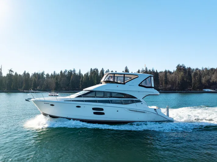  Yacht Photos Pics 2014 Meridian 441 Sedan cruising on a serene lake with forested shoreline.