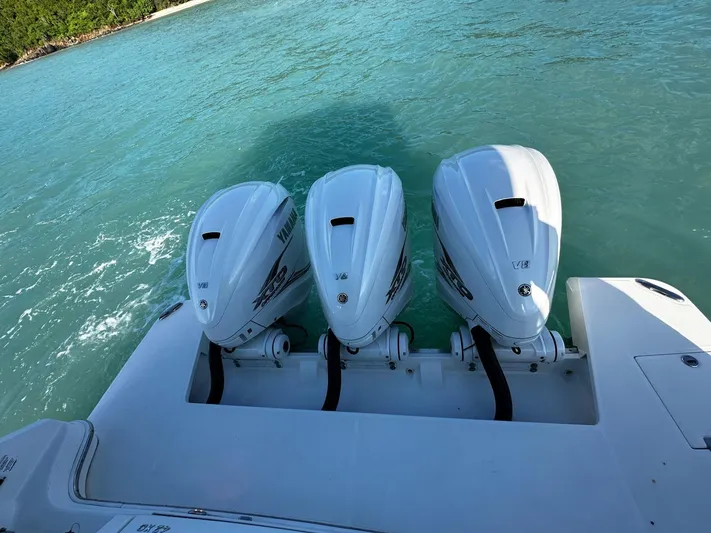  Yacht Photos Pics 2022 Regal 42 XO boat with triple outboard engines on turquoise water.
