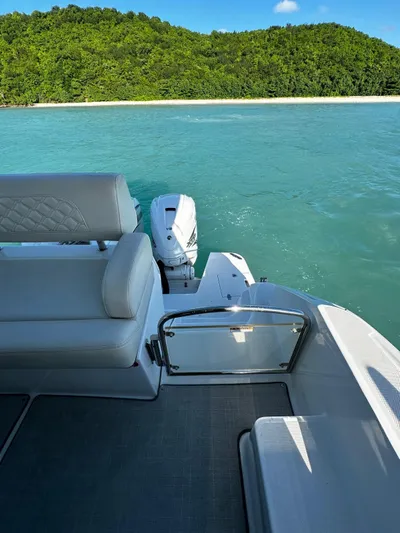 Yacht Photos Pics 2022 Regal 42 XO yacht on turquoise water near lush green island.