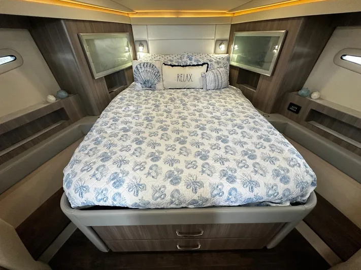  Yacht Photos Pics Luxurious 2022 Regal 42 XO yacht bedroom with elegant bedding and ambient lighting.