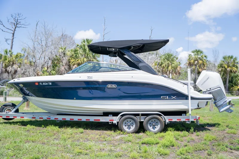  Yacht Photos Pics 2023 Sea Ray SLX 260 Outboard boat on trailer, parked on grass, under clear sky.