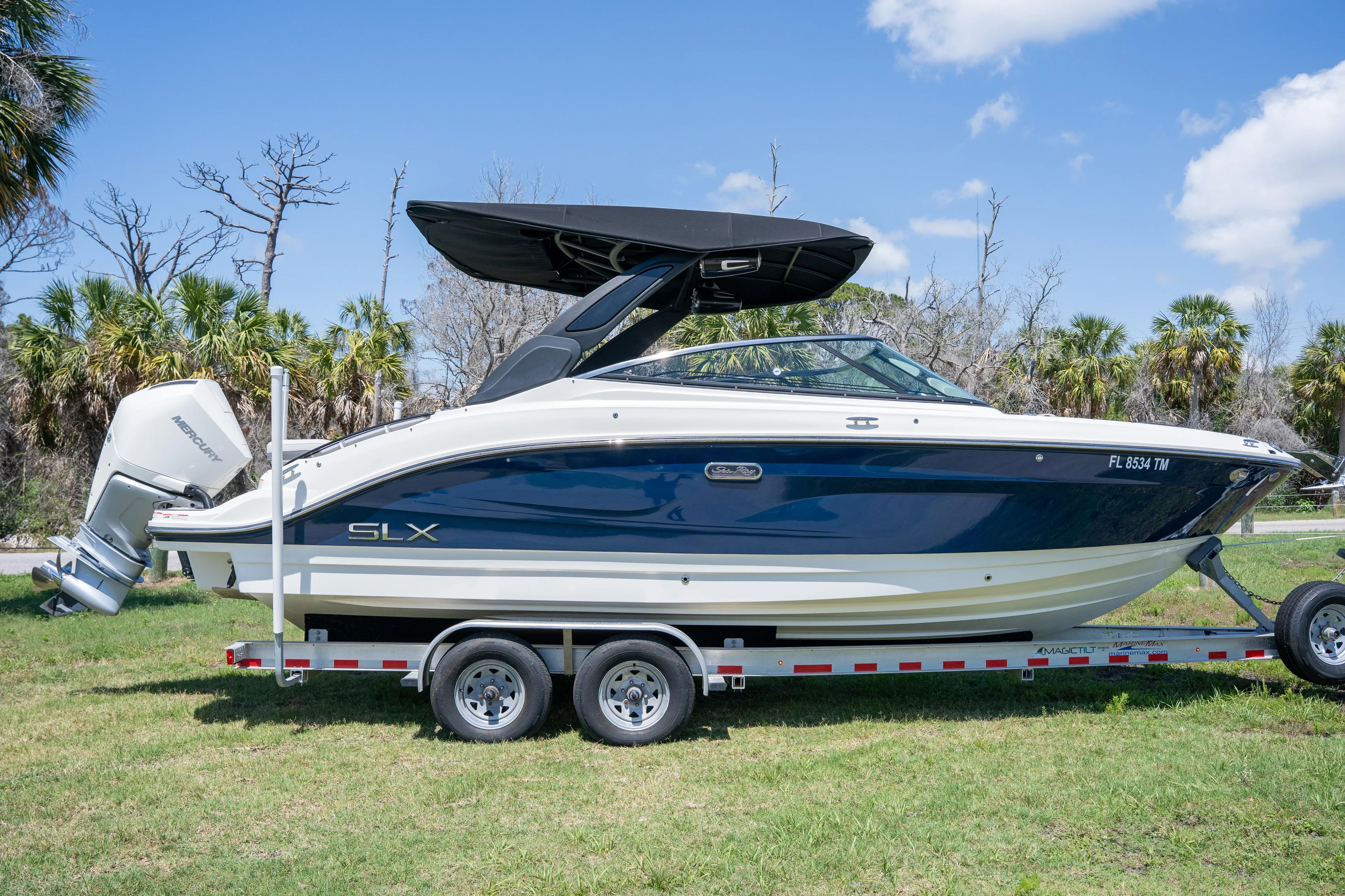  Yacht Photos Pics 2023 Sea Ray SLX 260 Outboard boat on trailer, parked on grass.