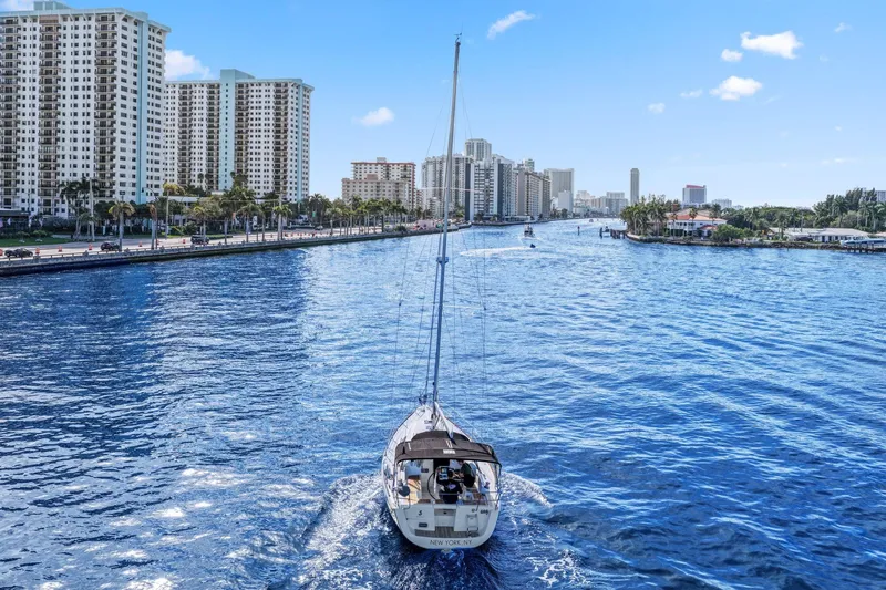 Americana Yacht Photos Pics Beneteau Oceanis 37 sailing in a city canal, surrounded by tall buildings, 2014 model.