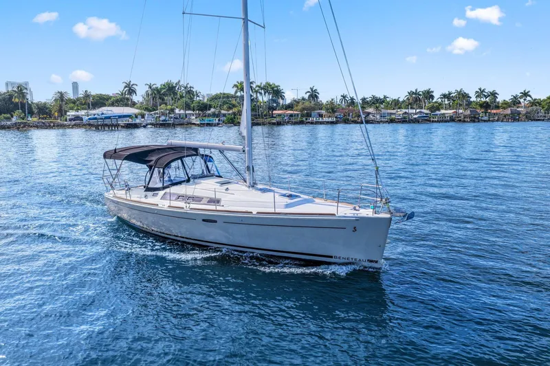 Americana Yacht Photos Pics 2014 Beneteau Oceanis 37 sailboat cruising on a sunny day, surrounded by palm trees.