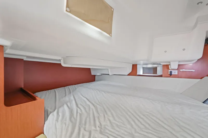 Americana Yacht Photos Pics Interior cabin of 2014 Beneteau Oceanis 37 sailboat, featuring a cozy bed and wooden accents.