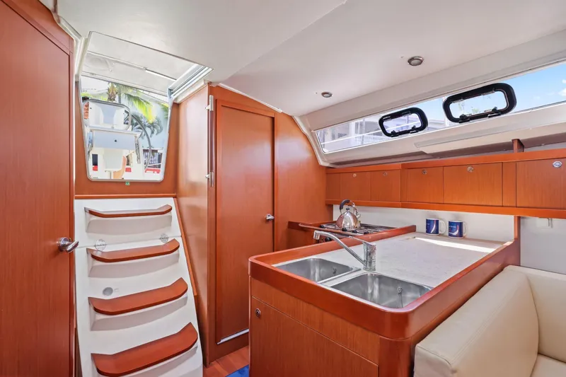 Americana Yacht Photos Pics Interior of 2014 Beneteau Oceanis 37 yacht with modern kitchen and wooden cabinetry.