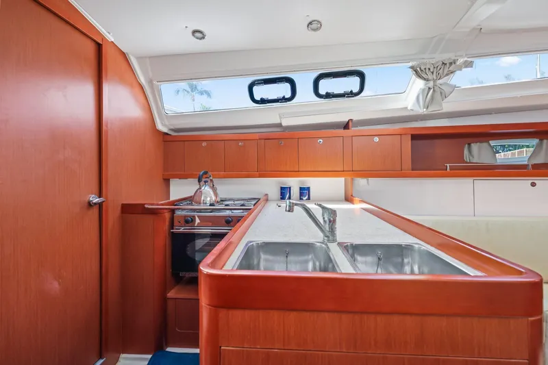 Americana Yacht Photos Pics Interior of 2014 Beneteau Oceanis 37 yacht kitchen with wood cabinetry and dual sinks.
