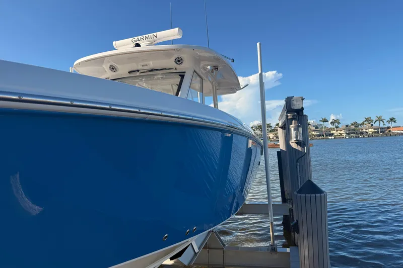  Yacht Photos Pics 2023 Everglades 395 Center Console boat docked by waterfront homes.