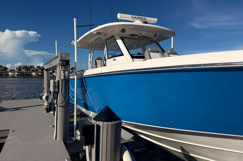  Yacht Photos Pics 2023 Everglades 395 Center Console boat docked, featuring a sleek blue hull.