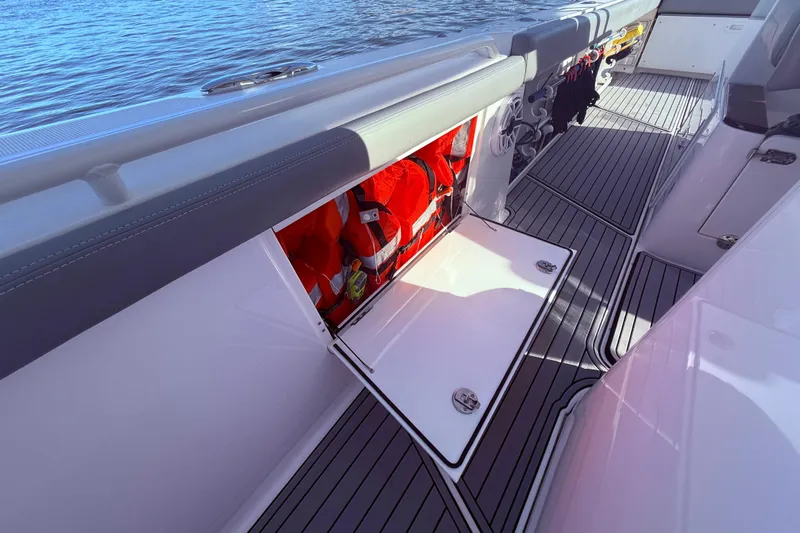  Yacht Photos Pics 2023 Everglades 395 Center Console boat with open storage compartment and life jackets.