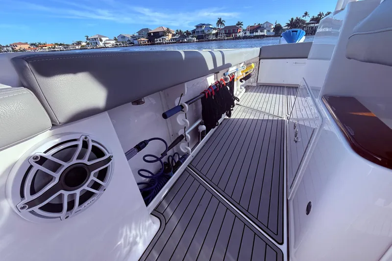  Yacht Photos Pics 2023 Everglades 395 Center Console boat interior with storage and speaker, docked by waterfront homes.