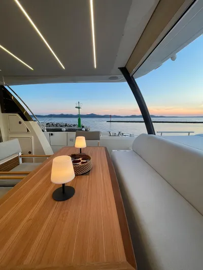 Bazinga Yacht Photos Pics Luxury yacht interior with elegant dining area, sunset view, Prestige 690, 2023 model.