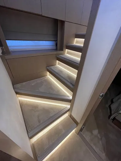 Bazinga Yacht Photos Pics Modern staircase with ambient lighting in 2023 Prestige 690 yacht interior.