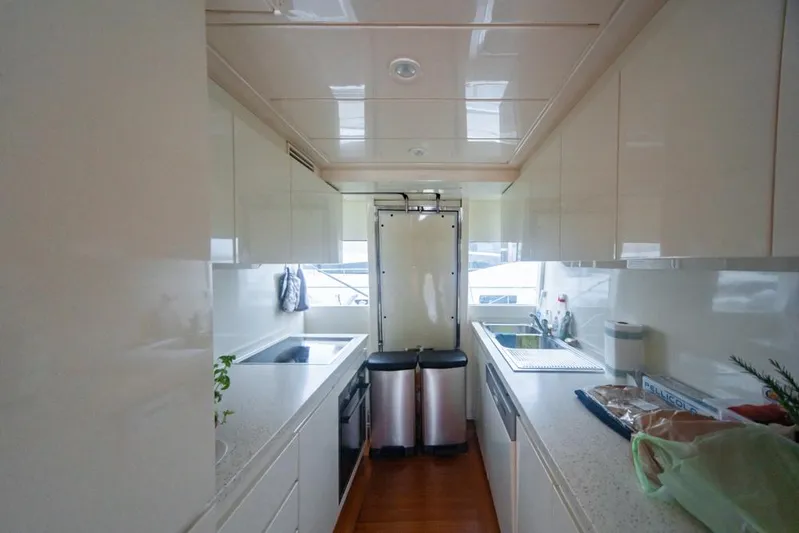  Yacht Photos Pics Modern yacht kitchen interior with sleek white cabinets, dual sinks, and stainless steel appliances. Diano 24, 2005.