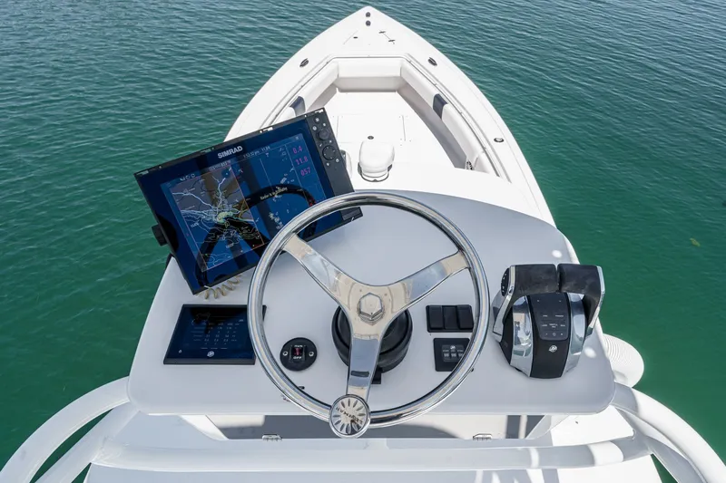 Go Time Yacht Photos Pics 2019 Fountain 38 CC boat helm with navigation system and controls on calm water.