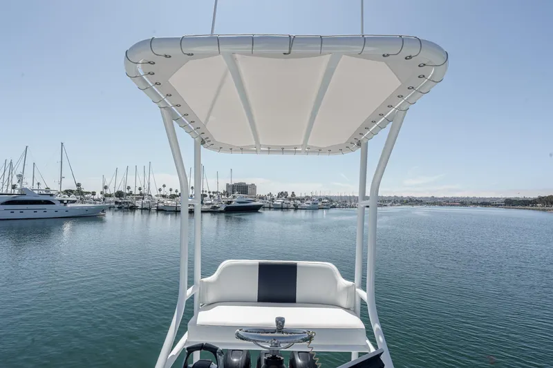 Go Time Yacht Photos Pics 2019 Fountain 38 CC boat helm with canopy, overlooking marina with yachts.