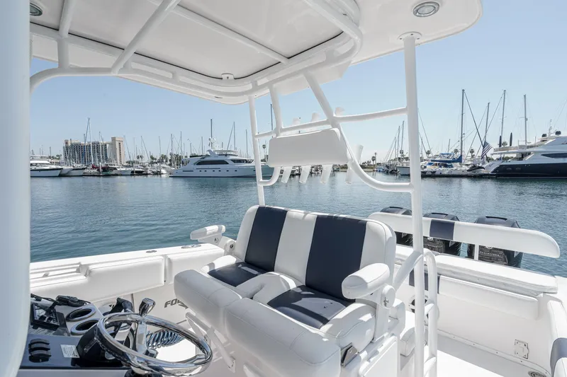 Go Time Yacht Photos Pics 2019 Fountain 38 CC boat interior with marina view, featuring sleek seating and steering wheel.