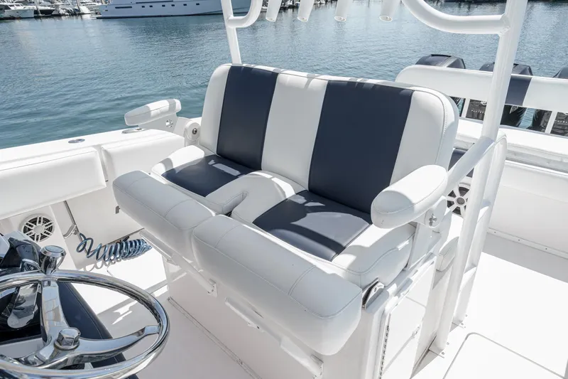 Go Time Yacht Photos Pics 2019 Fountain 38 CC boat interior with dual-tone seating and steering wheel, docked at marina.