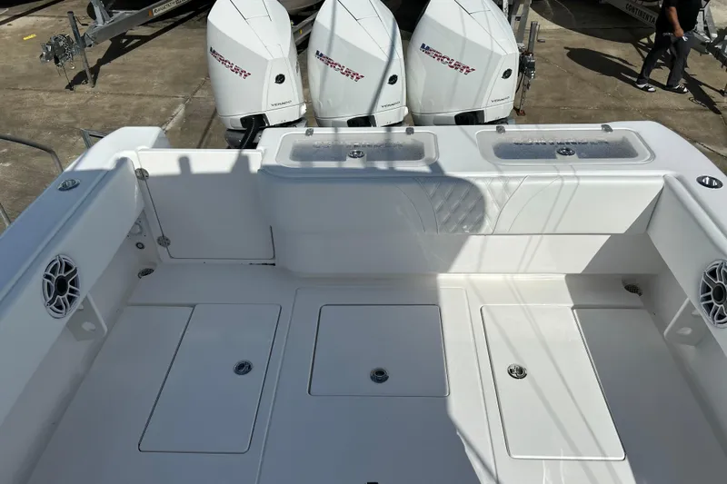  Yacht Photos Pics 2025 Contender 35 ST boat deck with Mercury engines, featuring storage compartments and speakers.